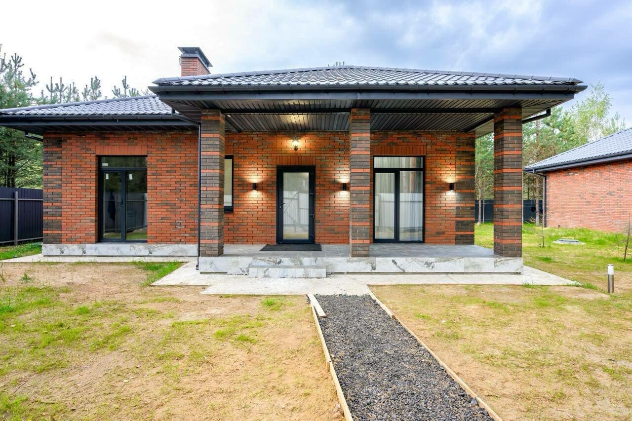 Кирпичный дом 142,5 м² с мансардой: фасад с террасой на колоннах